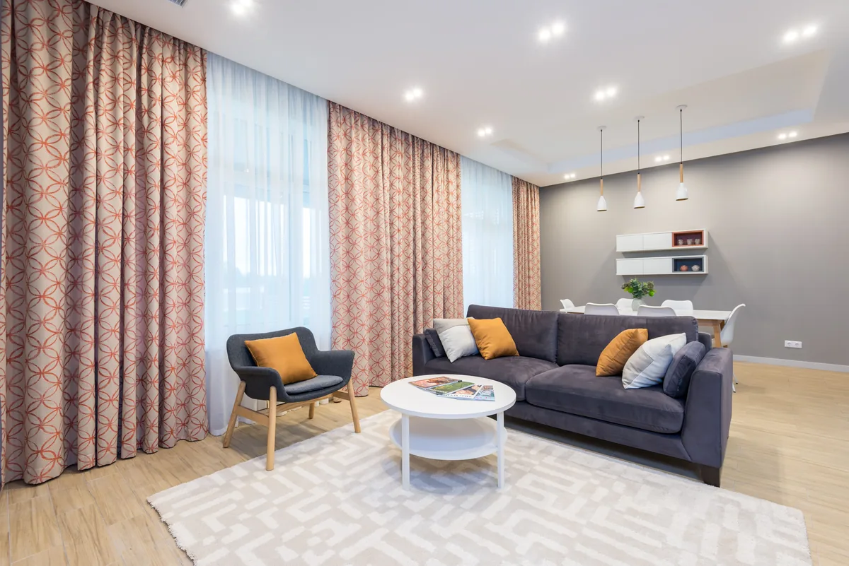 Séjour contemporain avec rideaux doublés et canapé bleu nuit